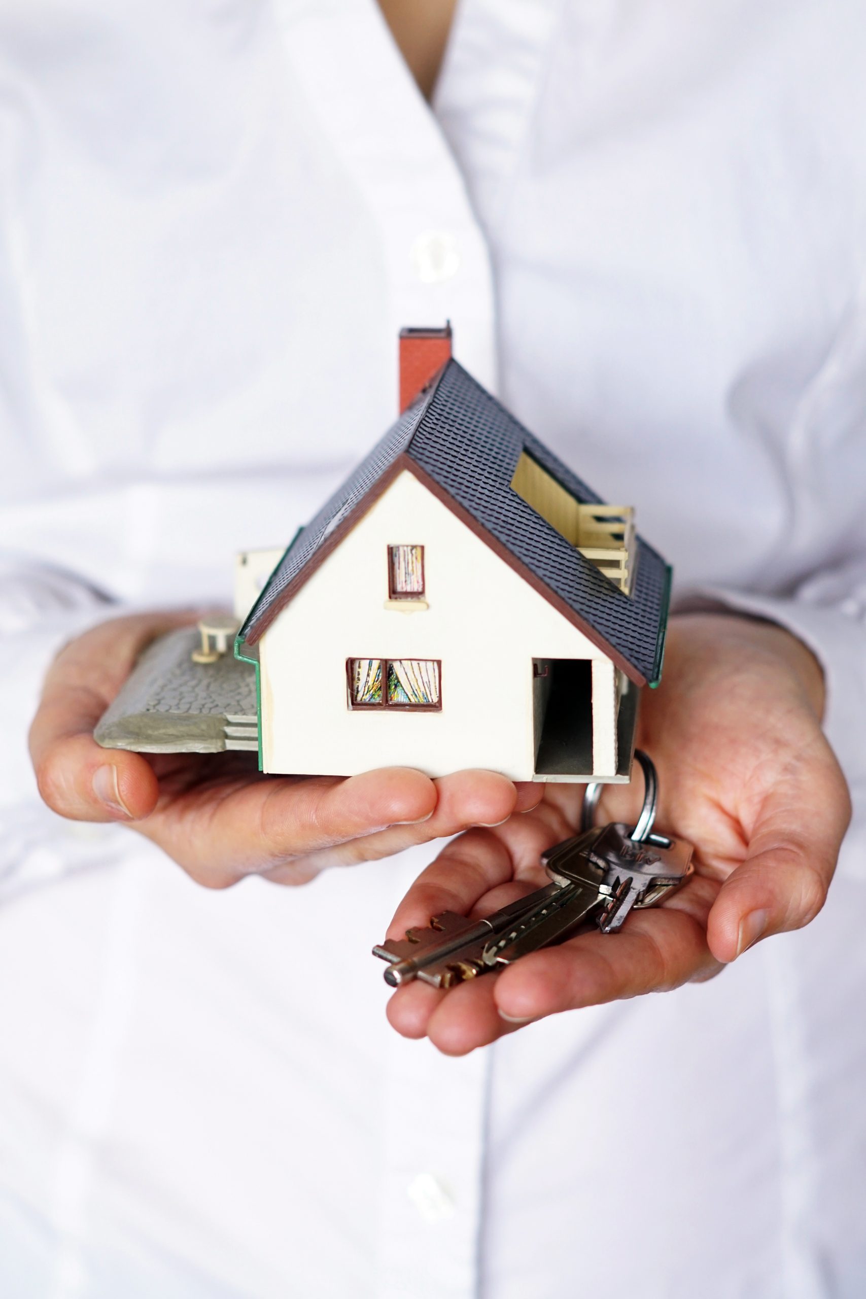 A vertical closeup shot of a person thinking of buying or selling a house